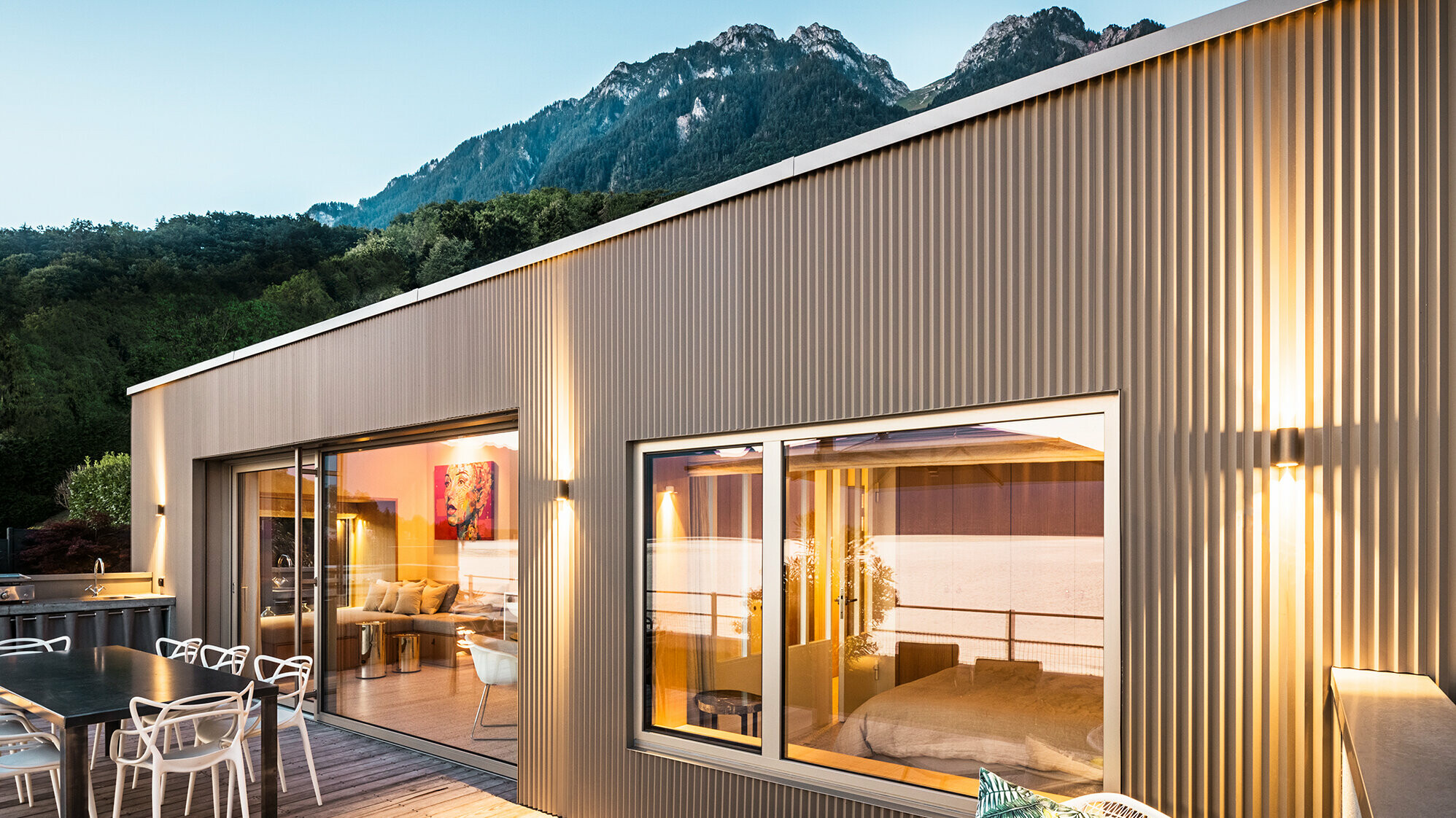 View of the terrace and part of the building interior in the evening.