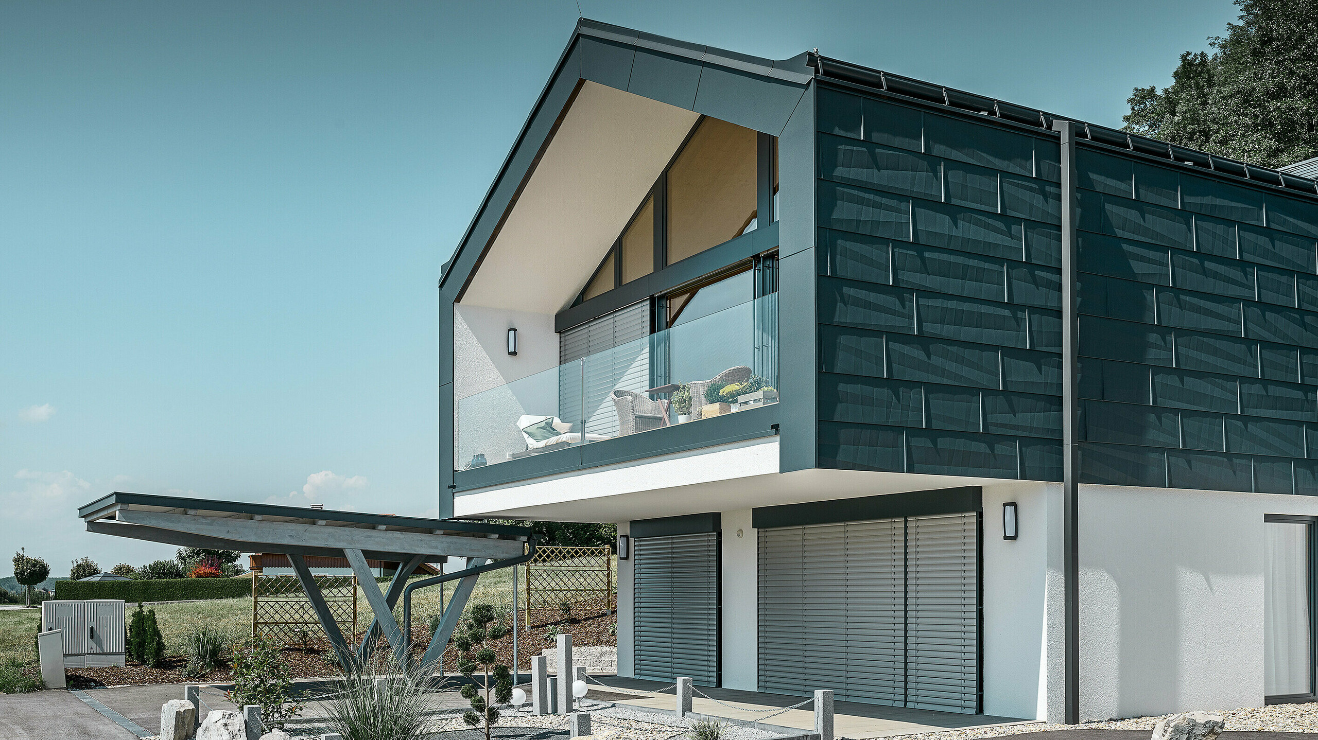 Façade cladding on the top floor using PREFA FX.12 façade panels in P.10 anthracite. The robust PREFA square downpipe is used for drainage.