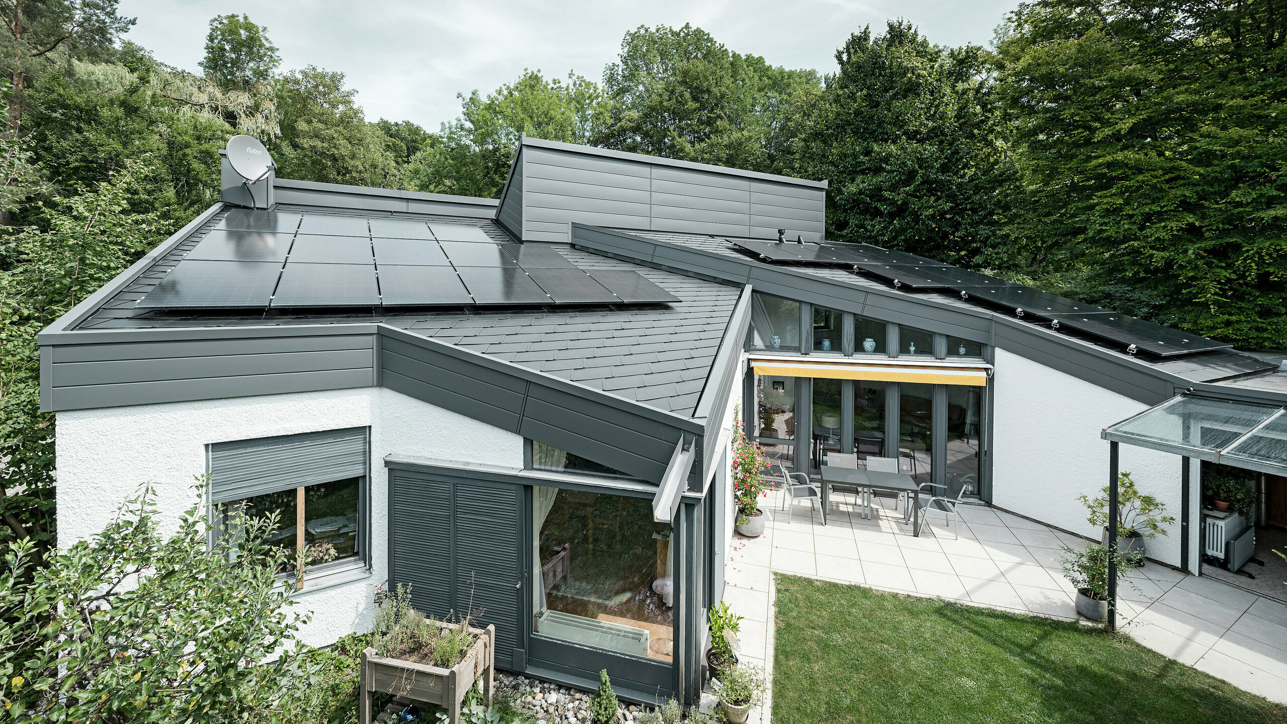 Ein Einfamilienhaus, das mit PREFA Dachschindeln DS.19 in schwarz eingedeckt wurde. Für Teile der Fassade wurden PREFA Sidings in P.10 dunkelgrau verwendet. 