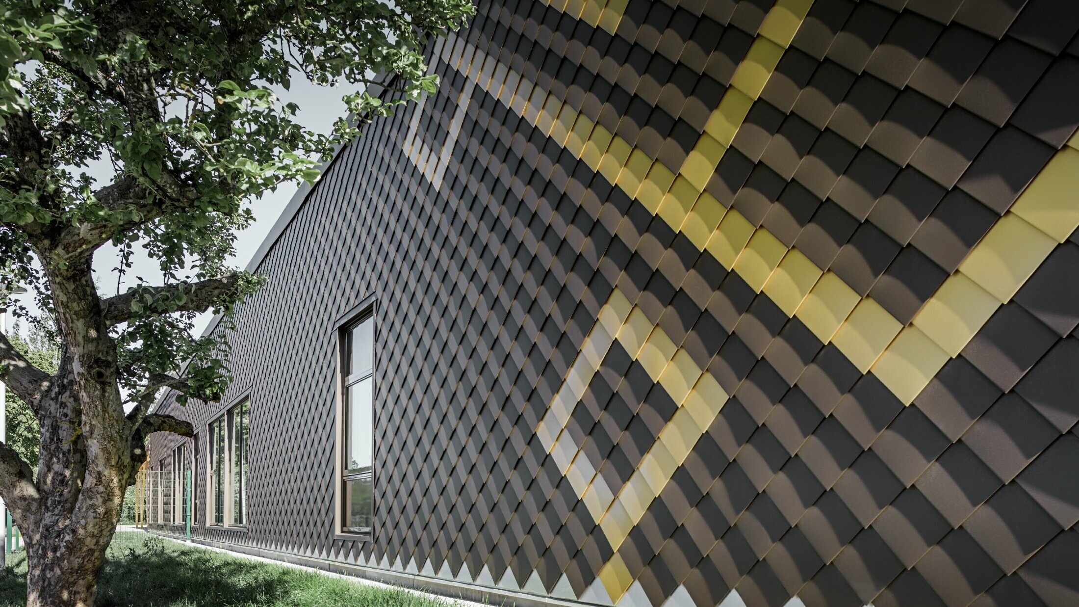 PREFA rhomboid tiles were used for the façade of the nursery school in Stockholm. The exterior façade is beautifully designed in brown and Mayan gold.
