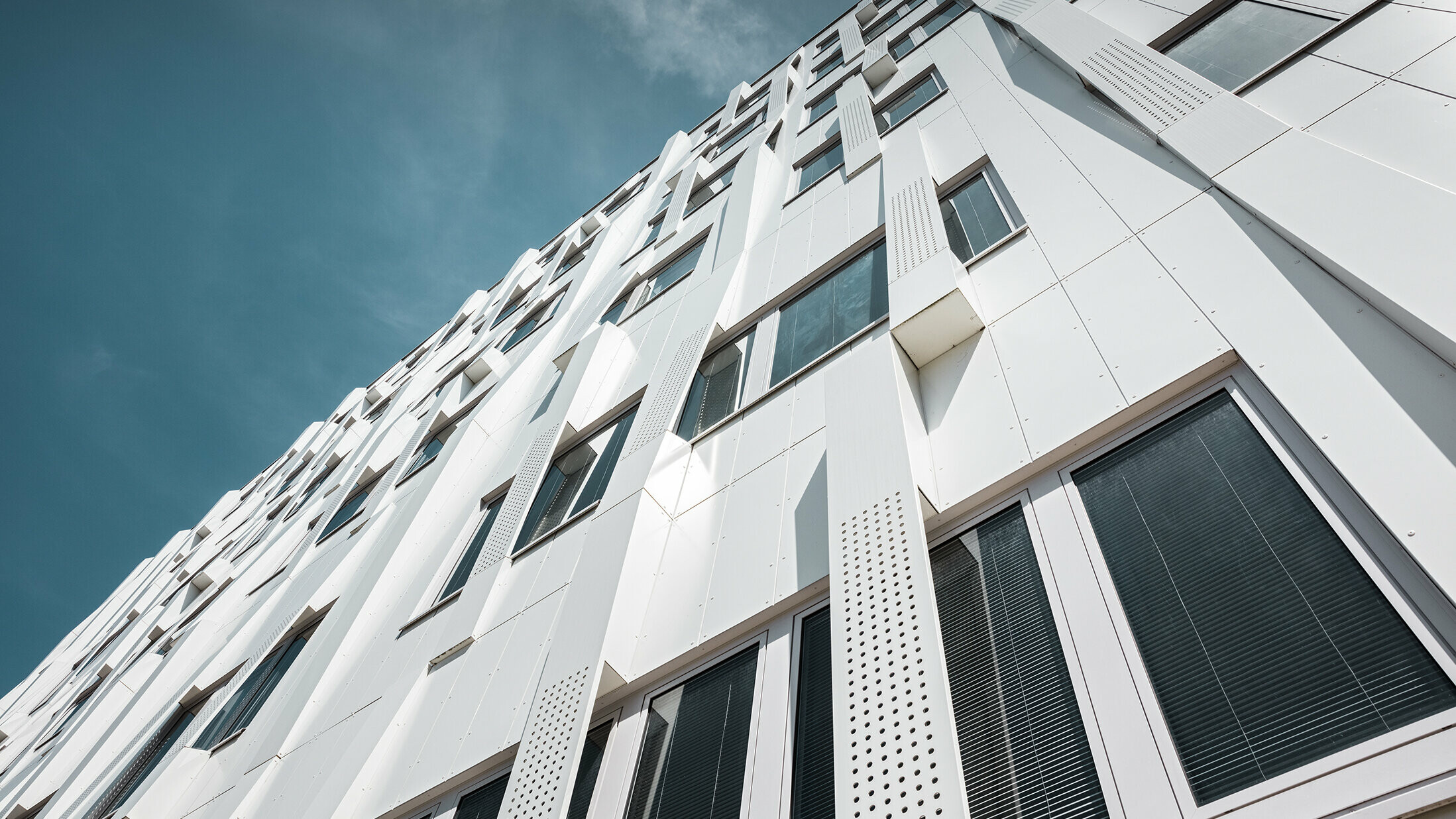 Special 3D façade, with perforated aluminium composite panel cassettes and normal PREFA composite panels in pure white, PREFA cassette façade