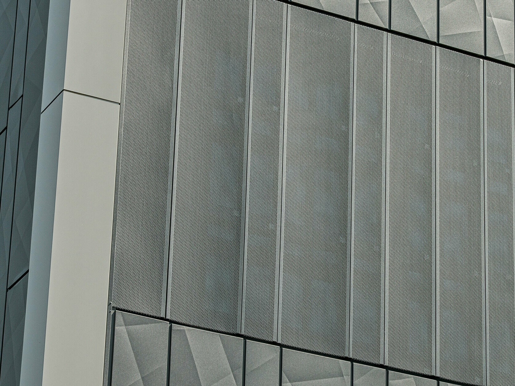 Facade view of a Eurospar supermarket in Rohrbach with PREFA Siding.X and perforated sidings in anthracite. The Siding.X elements feature a lively, geometric joint pattern, while the perforated Sidings offer a modern, air-permeable structure.