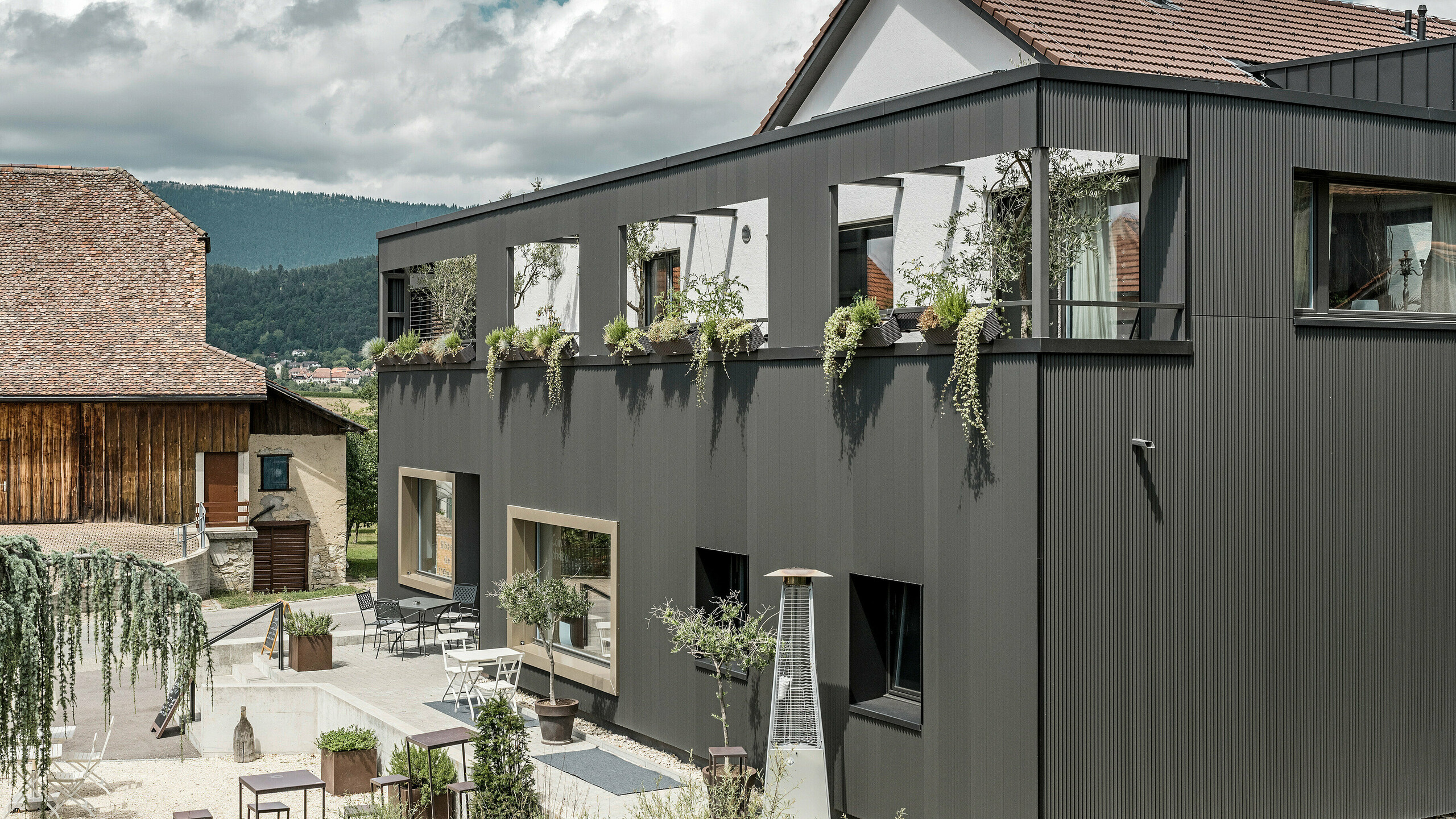 PREFA serrated profile in the special colour black grey on the Hôtel de l’Ours in Prêles, Switzerland