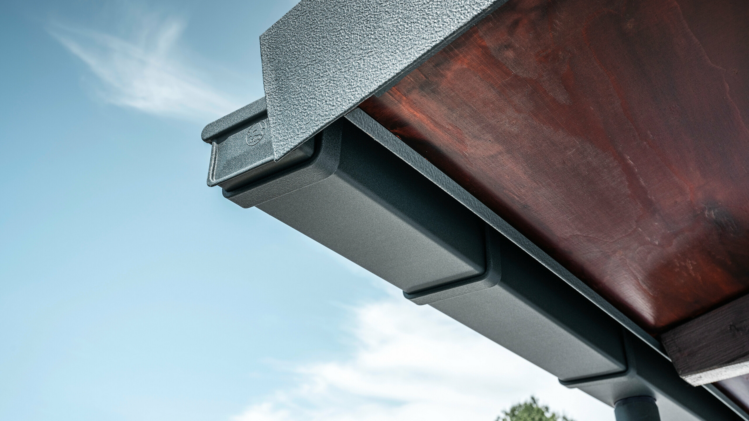 Detailed view of the PREFA roof drainage system in P.10 anthracite on the roof of a detached house in Dortmund.