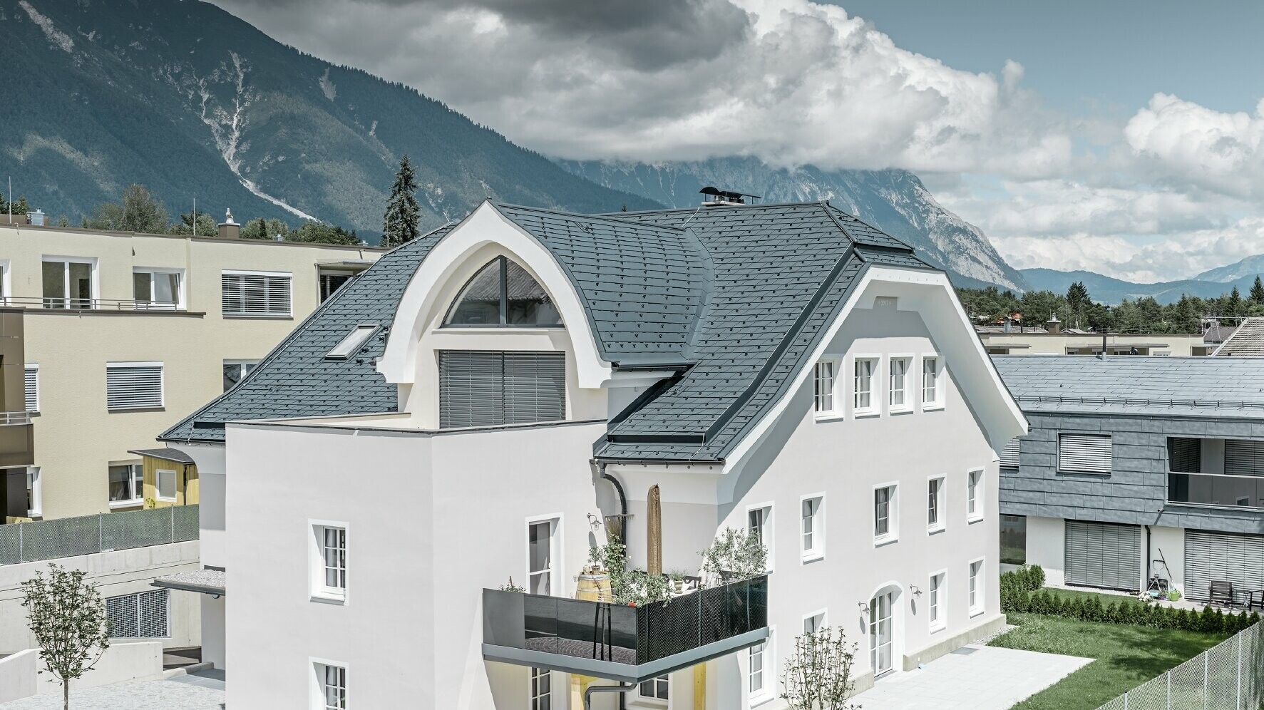 Newly renovated half-hipped roof with PREFA roof shingles in P.10 anthracite with curved dormer